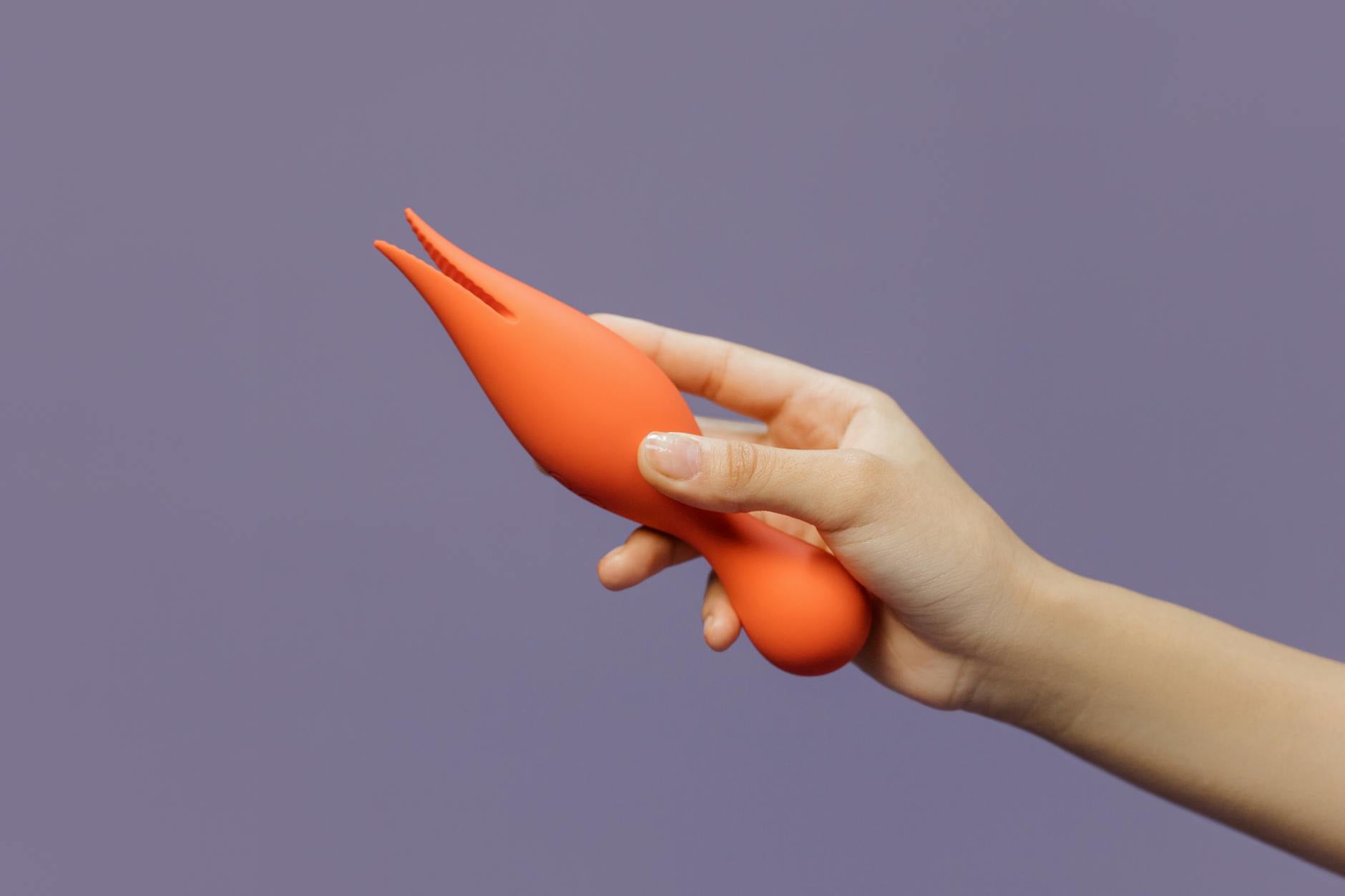 Una mano che tiene un limone su sfondo rosa morbido, simboleggiando freschezza e sensualità nella sessualità consapevole.