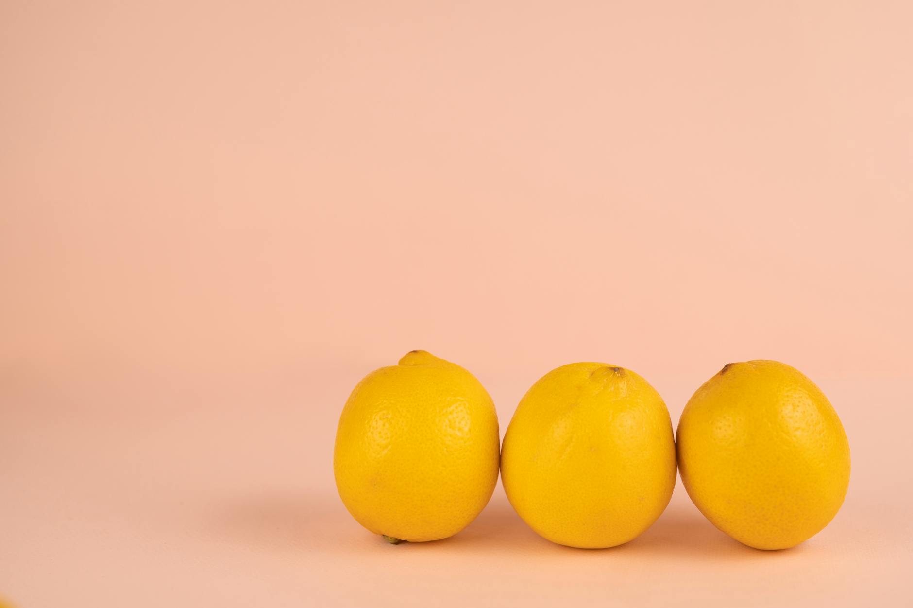 Limoni freschi e vibranti disposti su sfondo neutro, simbolo di rinascita del piacere